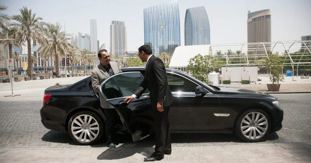 Luxury Tour Transportation with chauffeur and passenger entering a luxury car