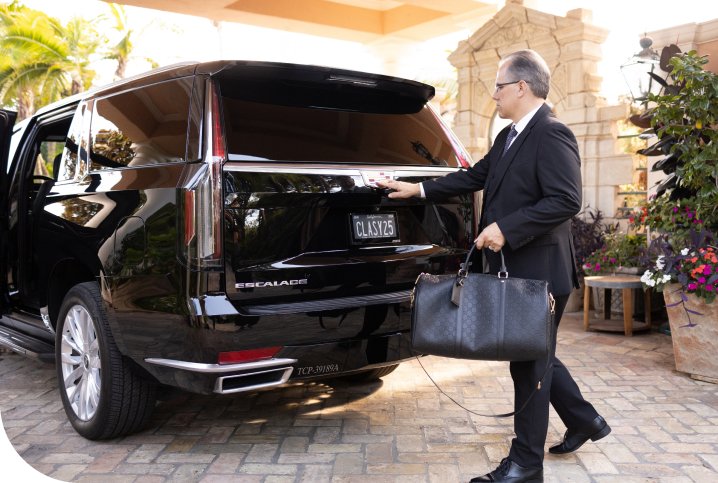 Limo Service Deerfield Beach with passenger loading luggage into luxury SUV