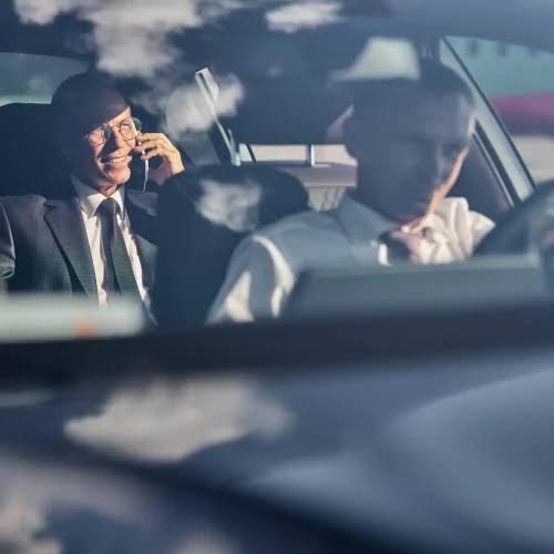 Corporate roadshow transport with executive passenger on phone and professional driver