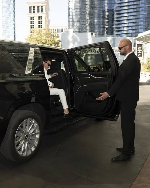 Hourly chauffeur service with professional driver opening luxury SUV door for client