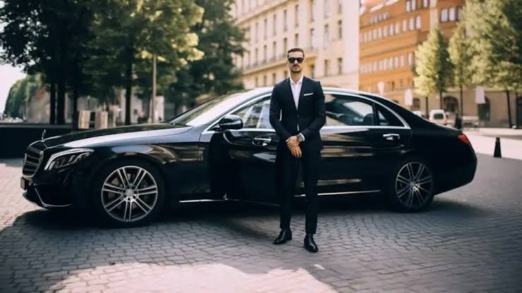 PBI airport car service with professional chauffeur standing by black luxury sedan