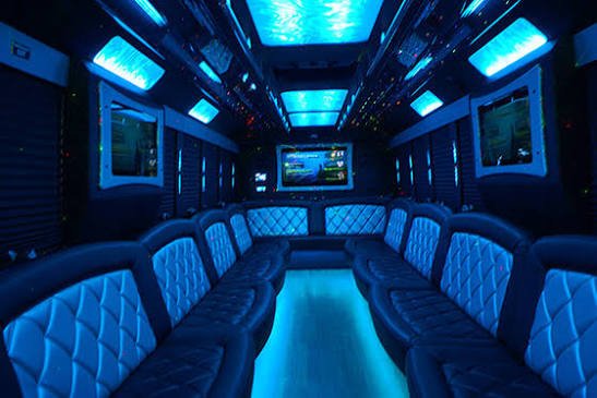 Party bus service interior with blue ambient LED lighting and comfortable leather seats