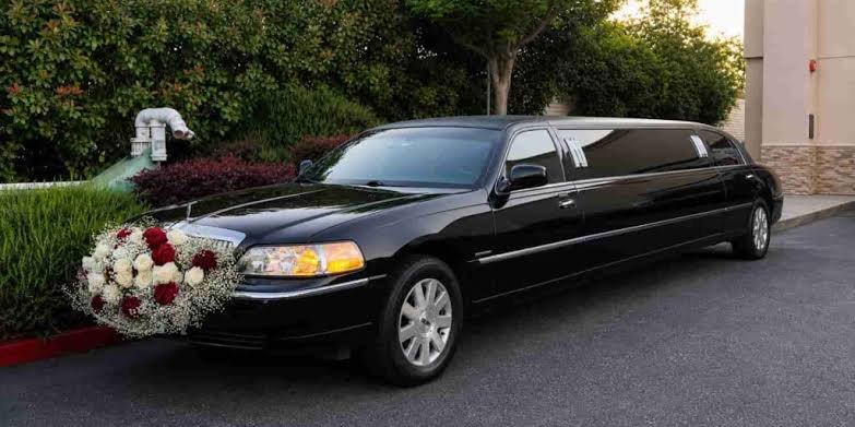 Wedding limo service with black stretch limousine decorated with red and white flowers