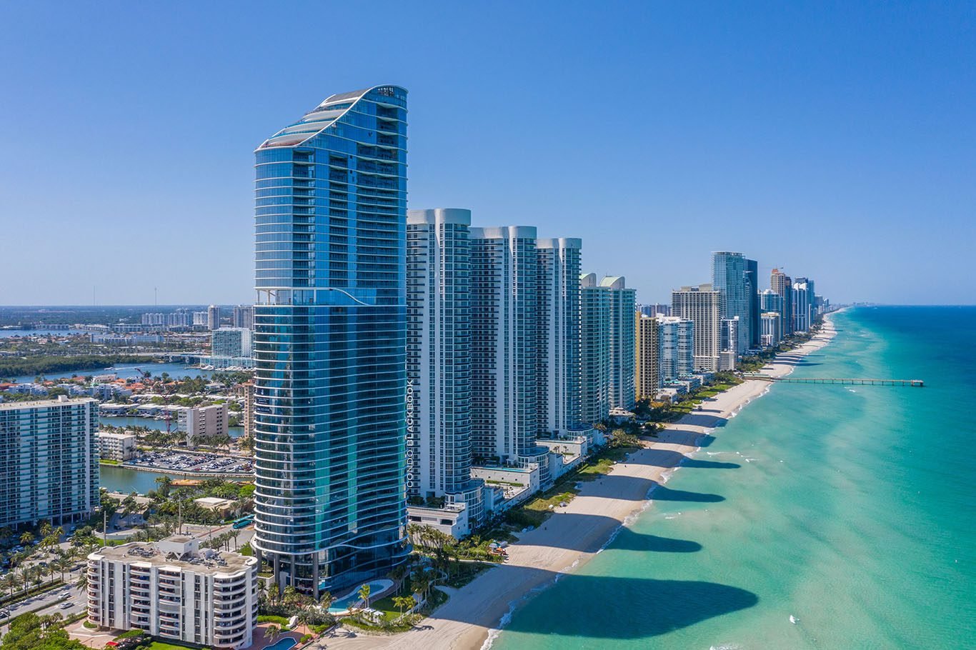 Sunny Isles Beach car service with aerial view of coastal skyscrapers and beach